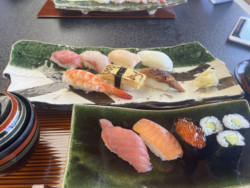 A comparison of sushi-handmade by participants in the front,and beautifully prepared by sushi chefs in the back.