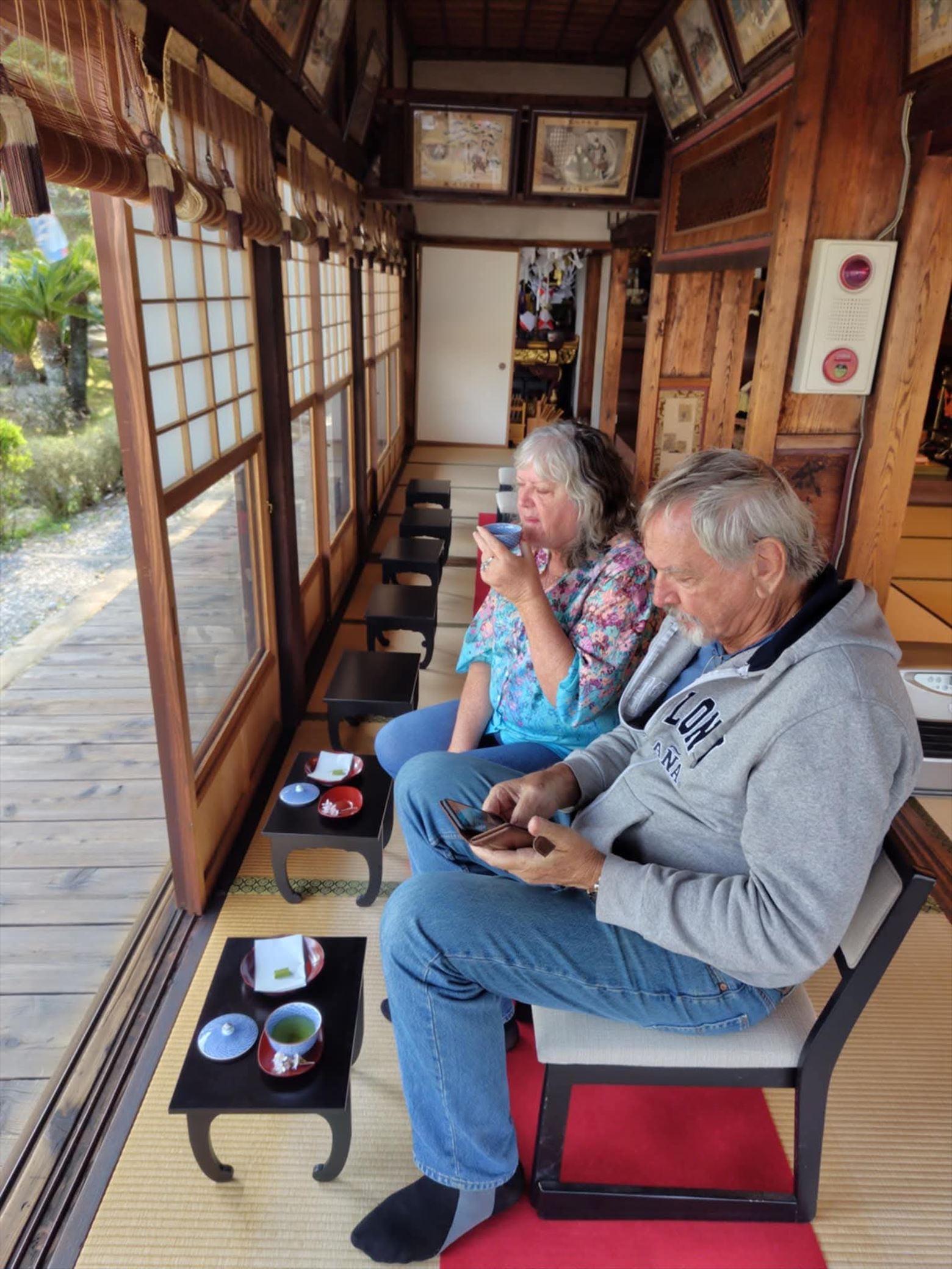 A tour guest enjoying premium Japanese green tea and Nanaya matcha chocolate while relaxing on a veranda at Ryugeji Temple.