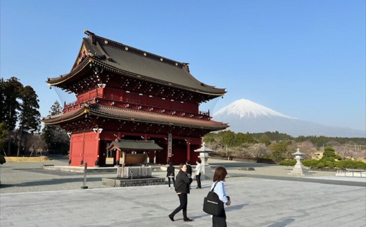 Red temple gate at Taisekiji Temple with clear view of Mt. Fuji, a peaceful shore excursion destination near Shimizu Port, Japan.