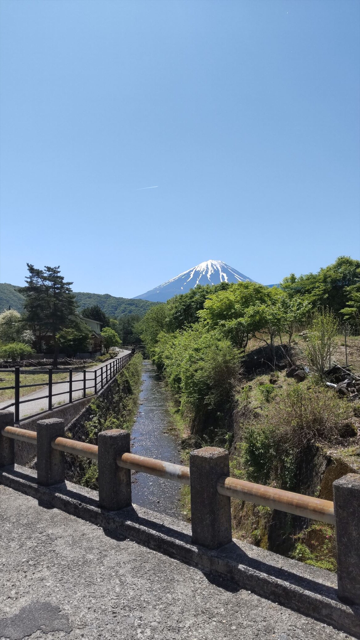 Clear stream with a distant view of Mt. Fuji in the background.
