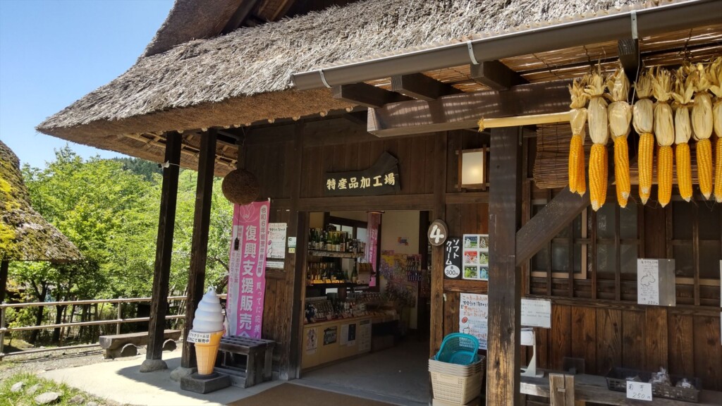 Thatched-roof shop with dried corn hanging outside,selling local snacks and souvenirs.