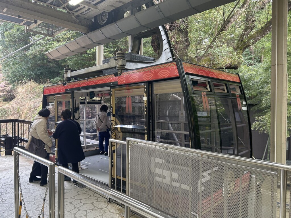 Tourists getting on the red ropeway at Nihondaira, starting their scenic journey to Kunozan Toshogu Shrine in Shizuoka, Japan.