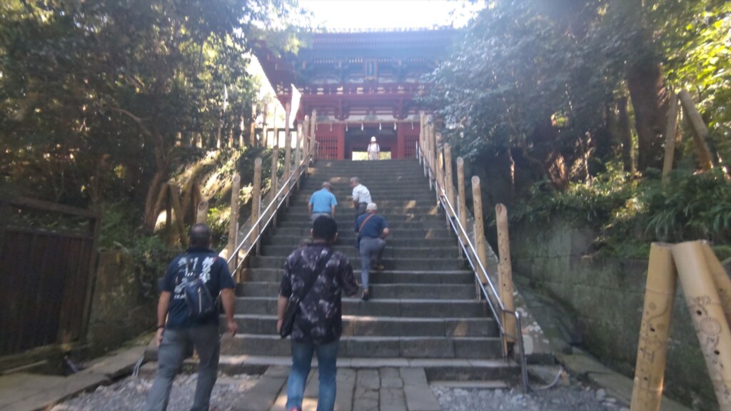 Tourists walking up the stairs toward the Romon gate at Kunozan Toshogu Shrine in Shizuoka, Japan—an ornate gate designated as an Important Cultural Property.