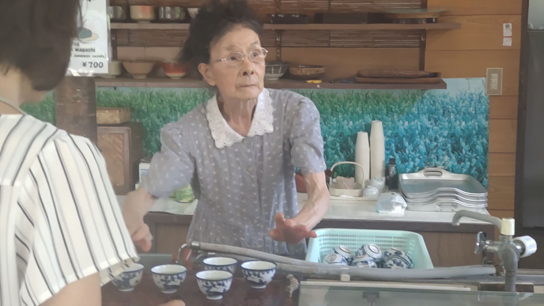 A elder woman serve some cup of japanese tea for rasting.Smell is so good.