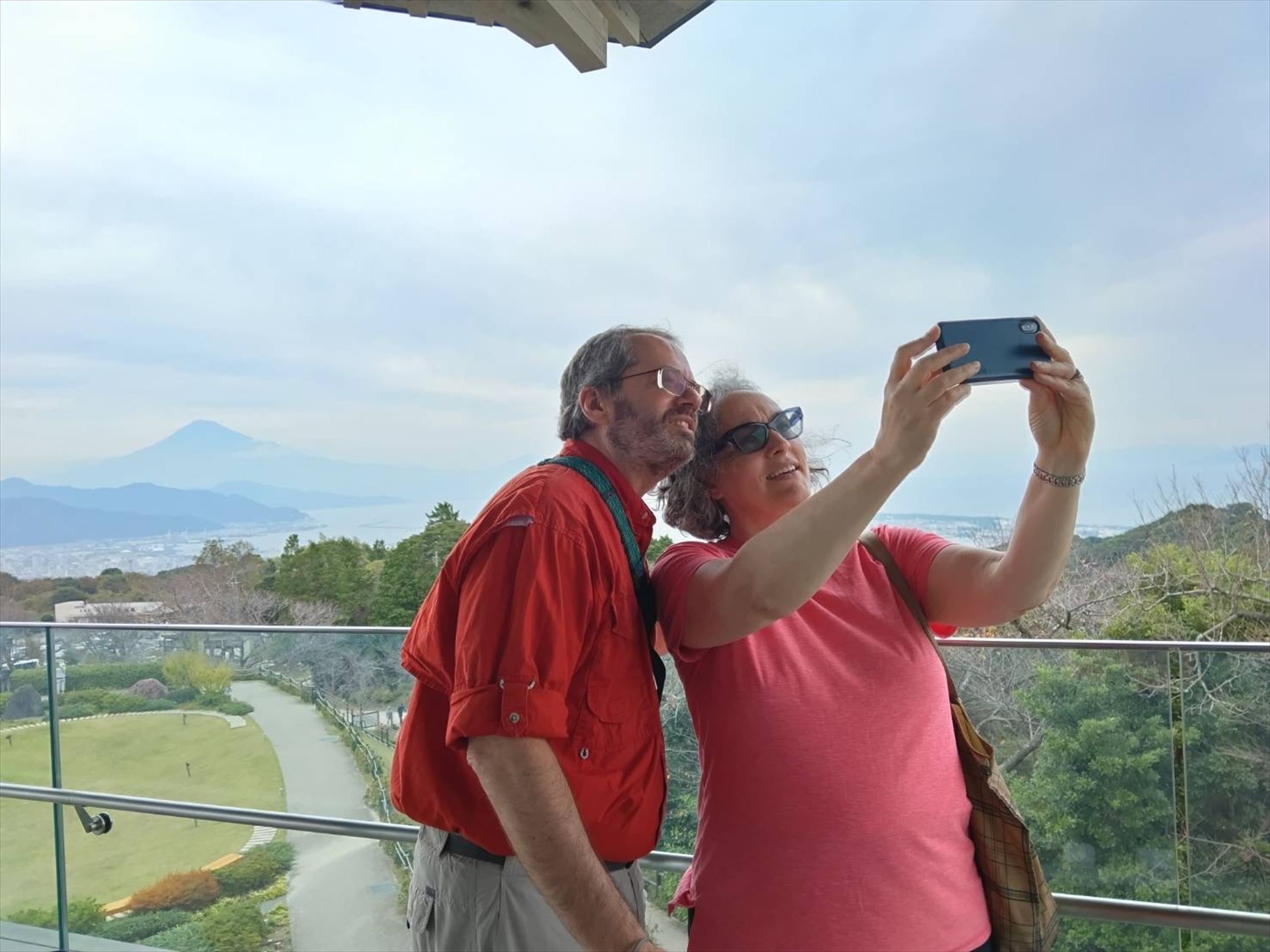 At the Yume terrace observation deck a couple takes selfie with smartphone.In the background , Mt.Fuji is completel obscured by clouds,creating a mystical and serene atmosphere.