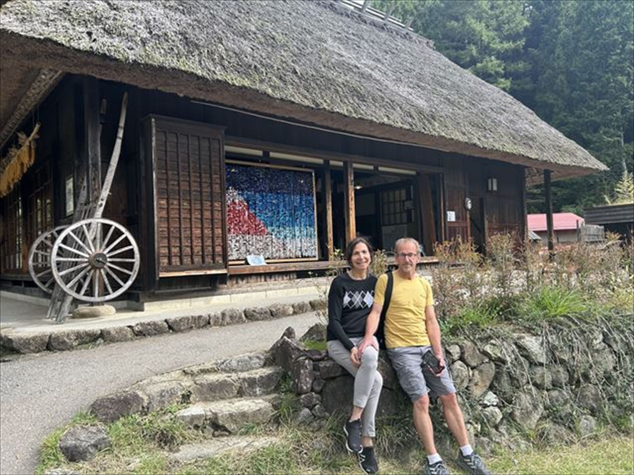 A couple are sitting in front of House where you can take a break while enjoying the view.