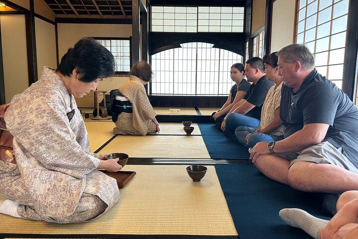 Close-up of a male guest adjusting his sitting posture during a tea ceremony in Shimada, highlighting the flexible and friendly nature of the experience.

