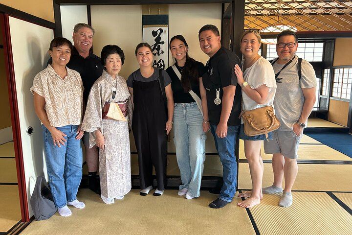Guests and tea ceremony instructor posing for a photo after the cultural activity, smiling and standing up after sitting in seiza style in Shimada, Japan.

