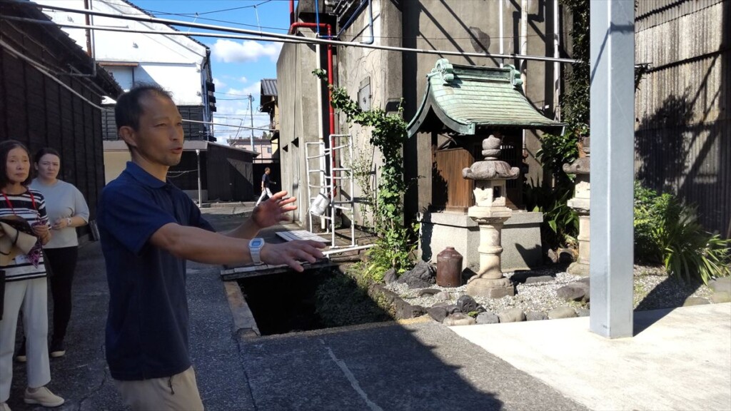 Brewery owner explaining the spring water system used in sake brewing at Takasago Brewery.